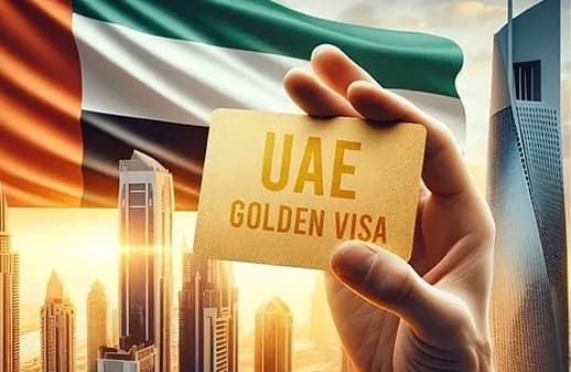 A UAE Golden Visa card held up against the Dubai skyline and the UAE flag